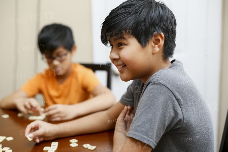 Native American boys playing spelling game at table