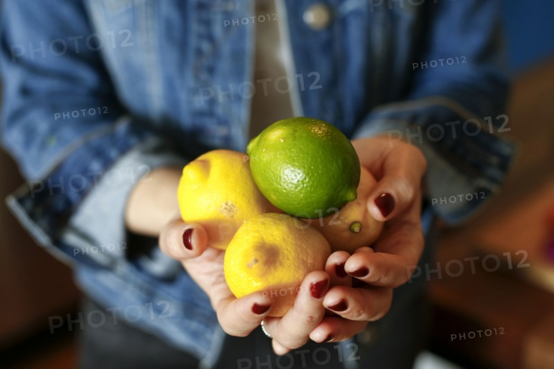 Hands of woman holding lemons and lime