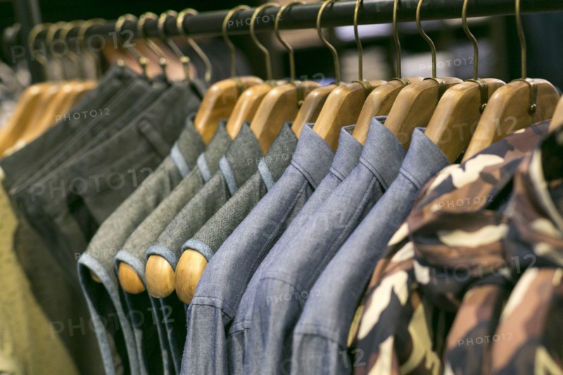 Shirts and pants hanging on clothing rack in retail store