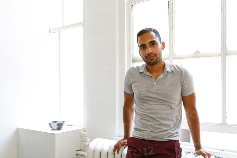 Mixed race man leaning on radiator