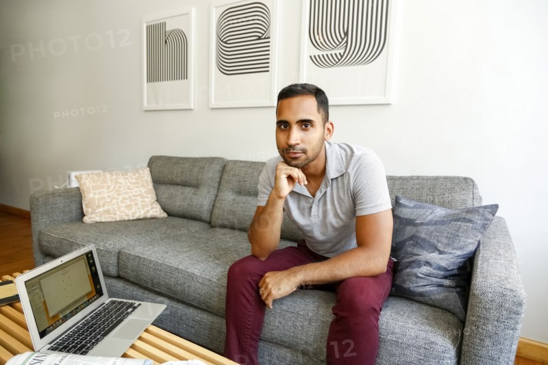Mixed race man relaxing on sofa near laptop