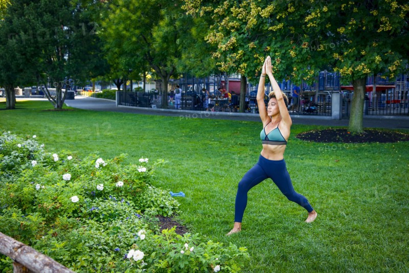 Mixed race woman performing yoga in park