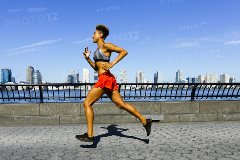 Mixed race woman running at waterfront