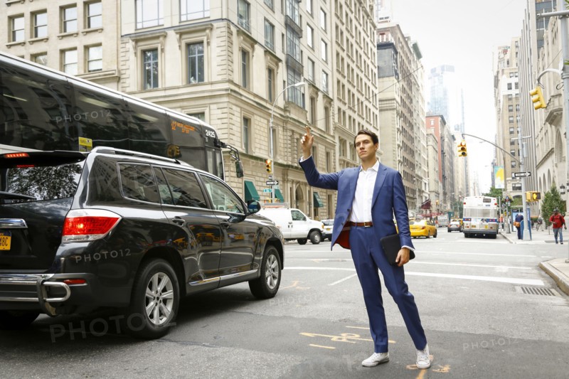 Caucasian businessman standing in street hailing taxi