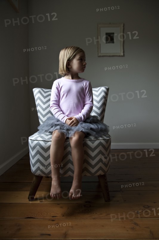 Mixed race girl sitting on chair