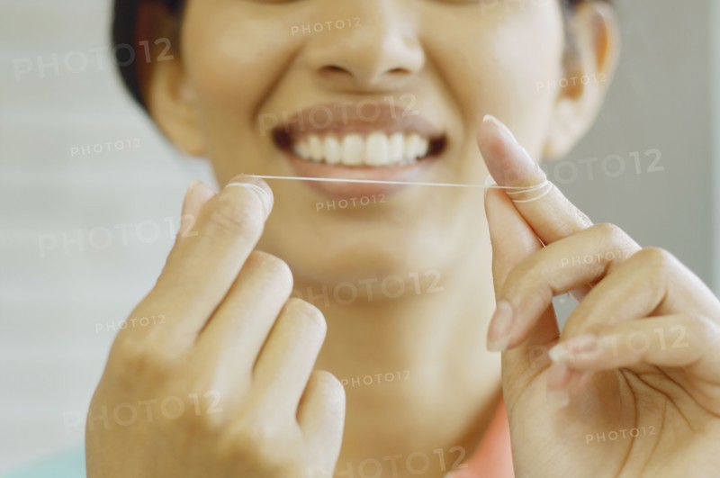 Woman smiling and holding dental floss