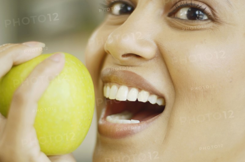 Close up of woman about to bite into an apple