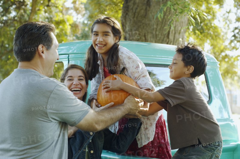 Multi-ethnic family holding pumpkin