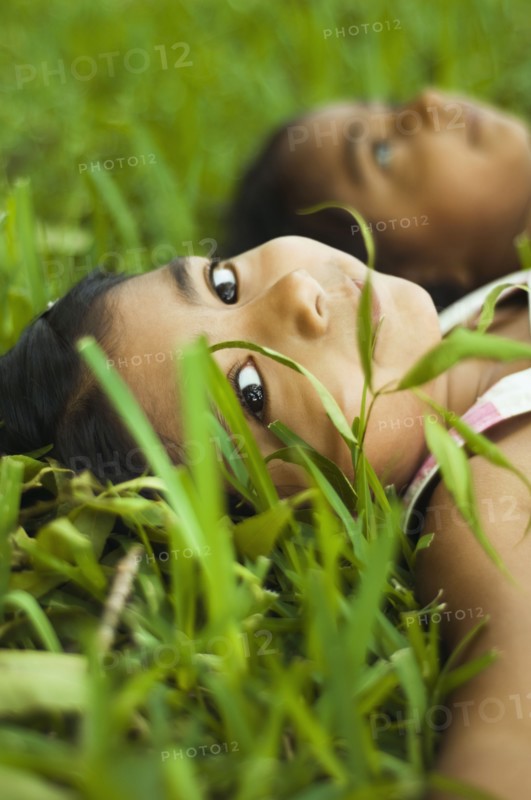 Indian girls laying in grass