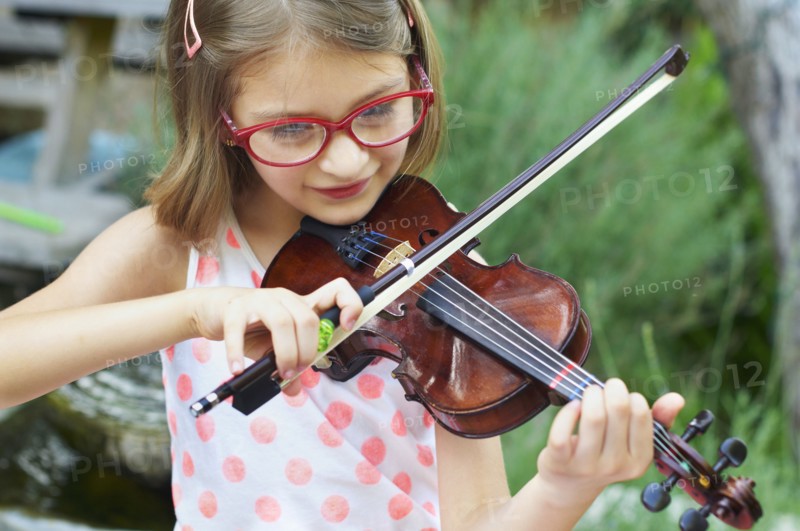 Hispanic girl playing violin outdoors