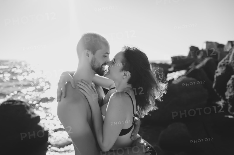 Caucasian couple hugging on sunny beach