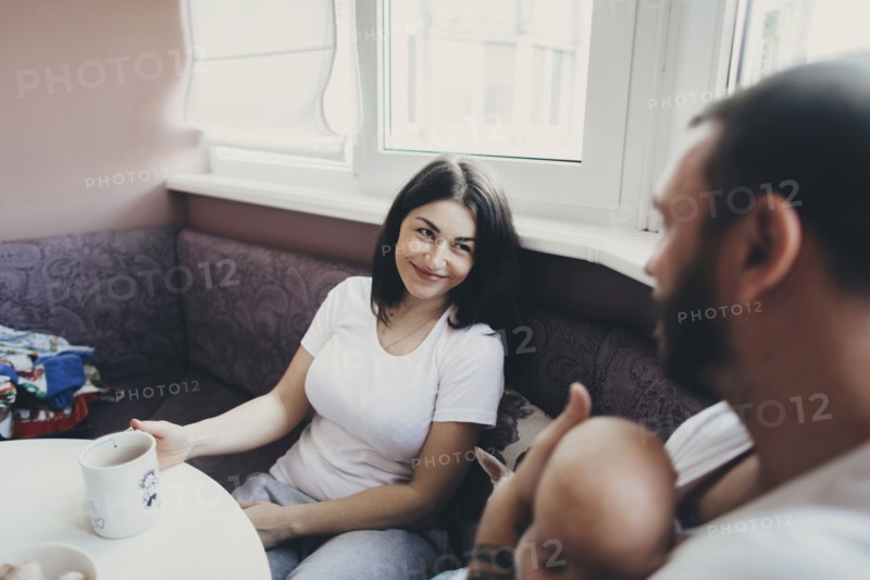 Caucasian mother and daughter sitting at table with baby son