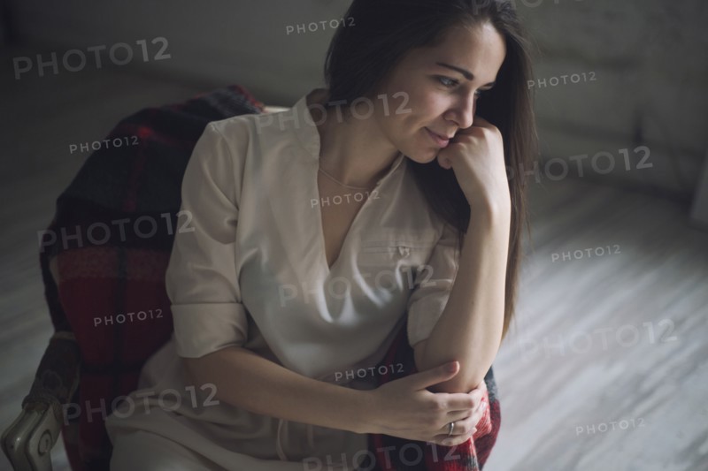 Pensive Caucasian woman sitting in chair