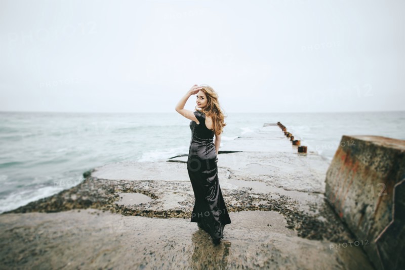 Portrait of smiling Caucasian woman wearing dress near ocean