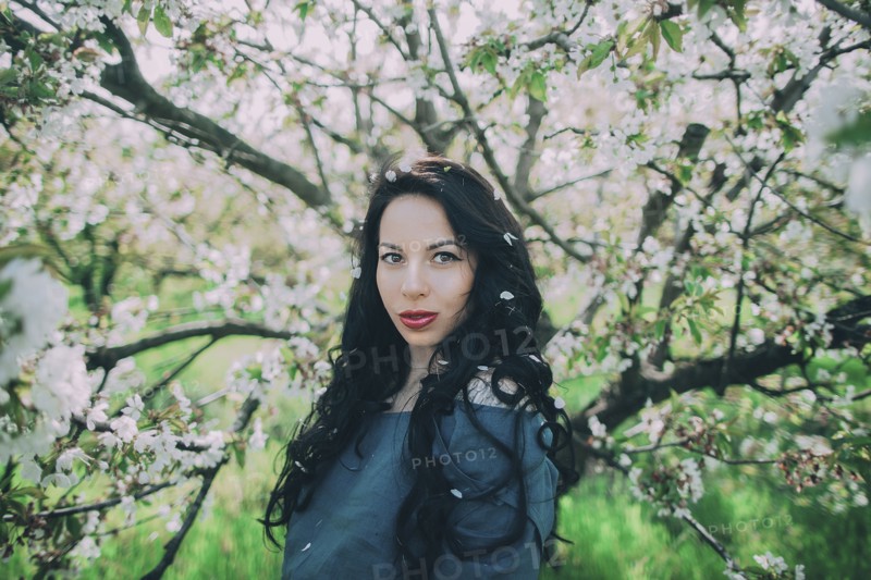 Caucasian woman posing near flowering tree