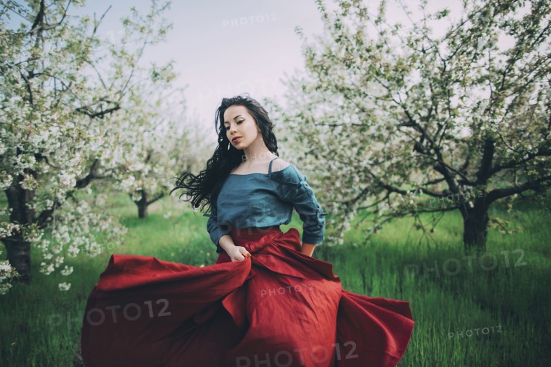 Caucasian woman dancing near flowering trees