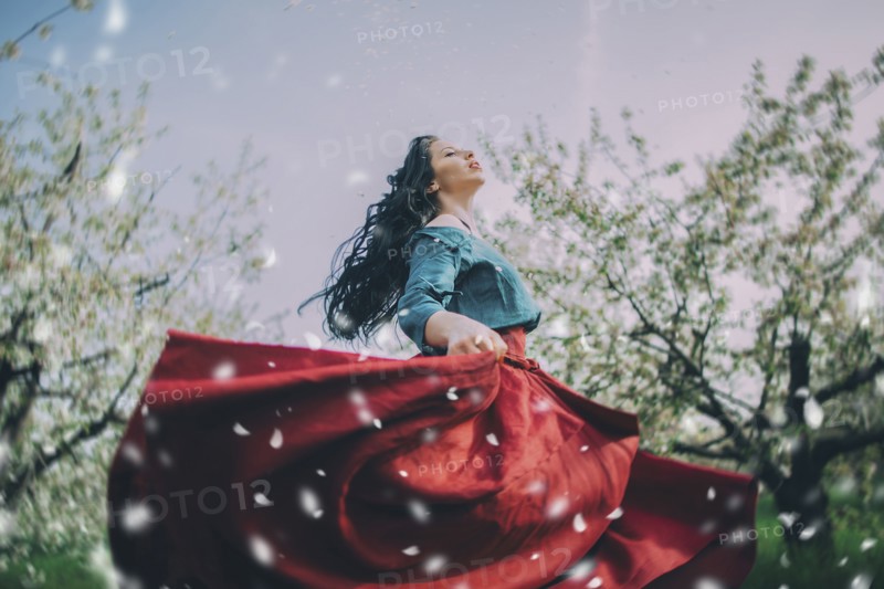 Caucasian woman dancing near flowering trees