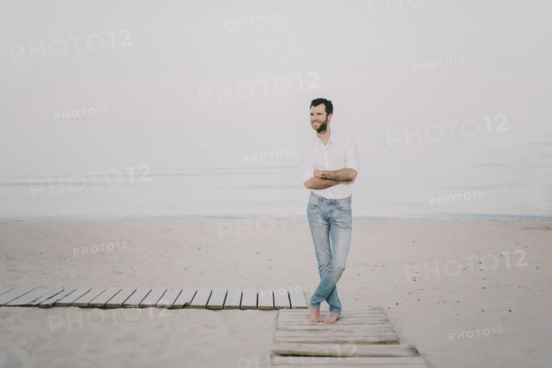Caucasian man standing on boardwalk at beach
