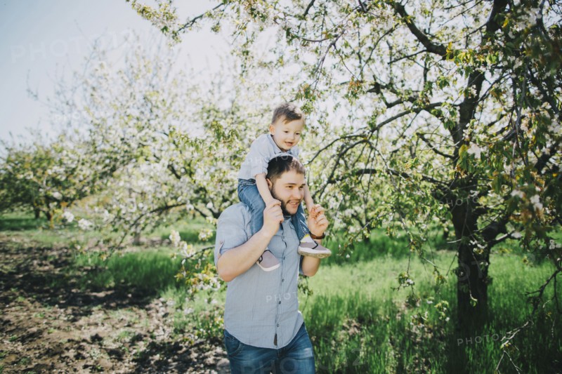 Caucasian father and son walking near tree