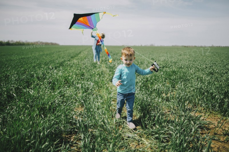 Caucasian boy and grandmother flying kite in field