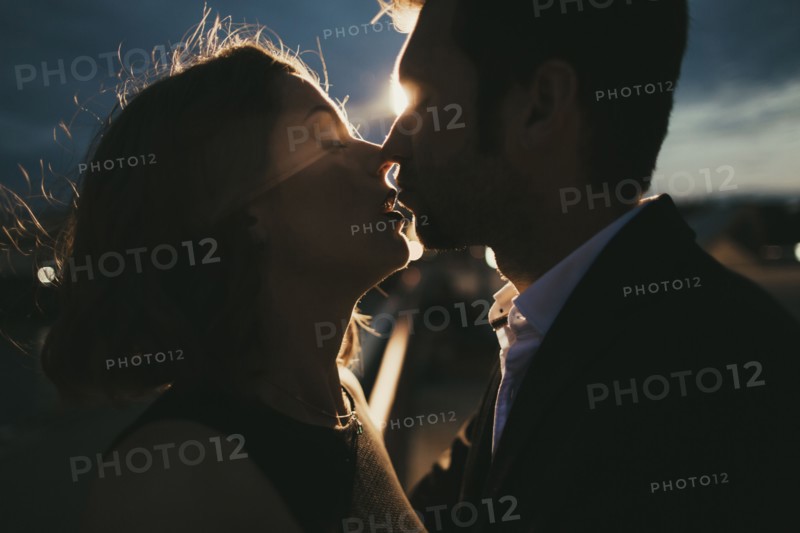 Caucasian couple kissing at night