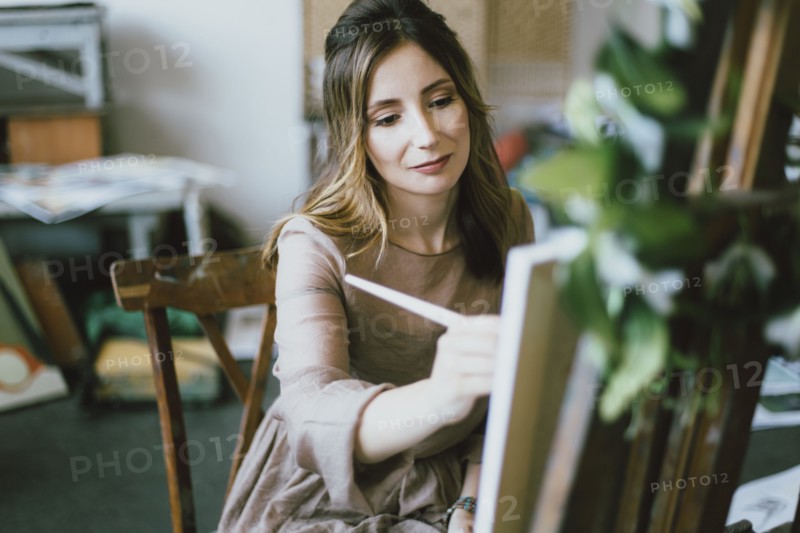 Caucasian woman painting on canvas