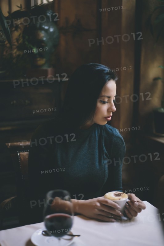 Pensive Caucasian woman drinking coffee