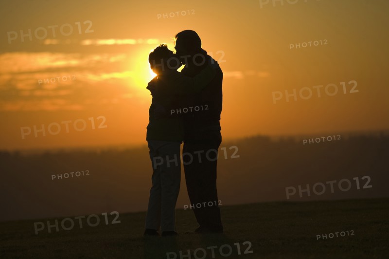 Hispanic couple kissing outdoors at sunset