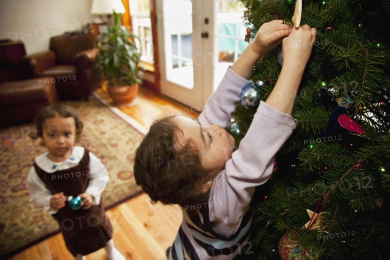 Mixed race girl decorating Christmas tree