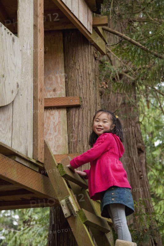 Korean girl climbing into tree house