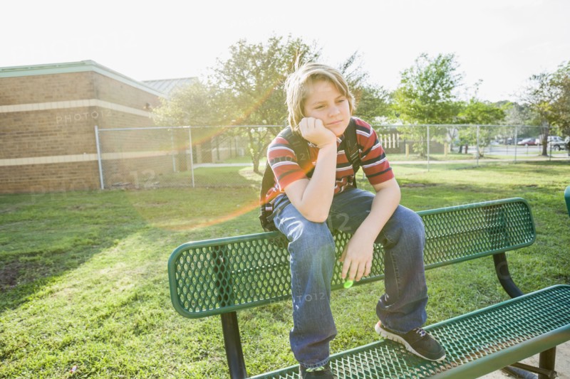 Caucasian boy sitting on bench