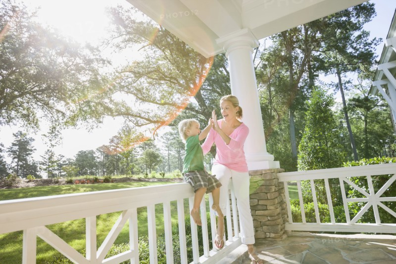 Caucasian mother and son playing on porch together