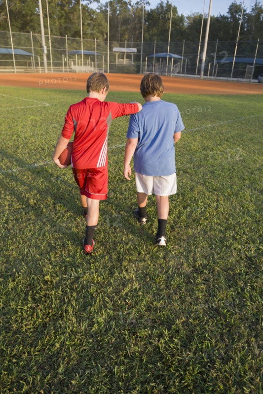 Caucasian boys walking in field