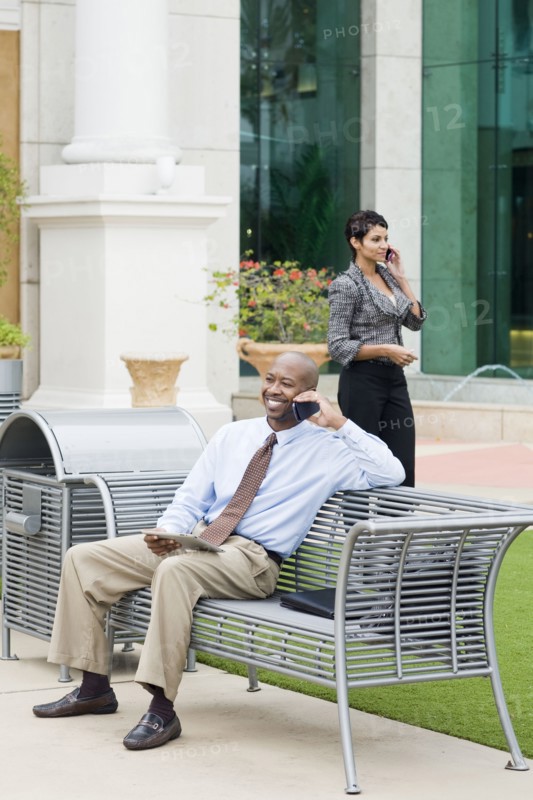 Business people talking on cell phones outdoors