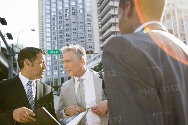 Businessmen talking on city street