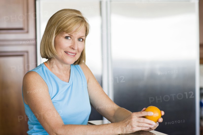 Caucasian woman peeling fruit in kitchen