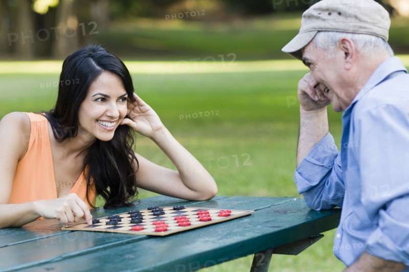 Hispanic father and daughter playing checkers