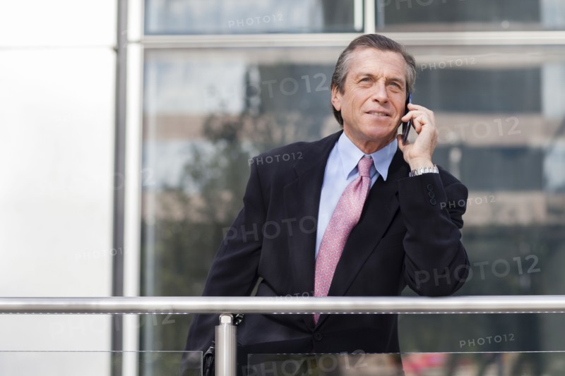 Caucasian businessman on cell phone on balcony
