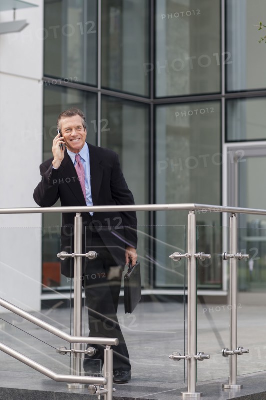 Caucasian businessman on cell phone outside building