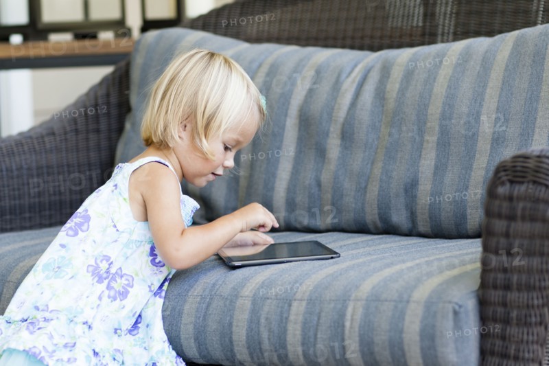 Caucasian girl using digital tablet on sofa