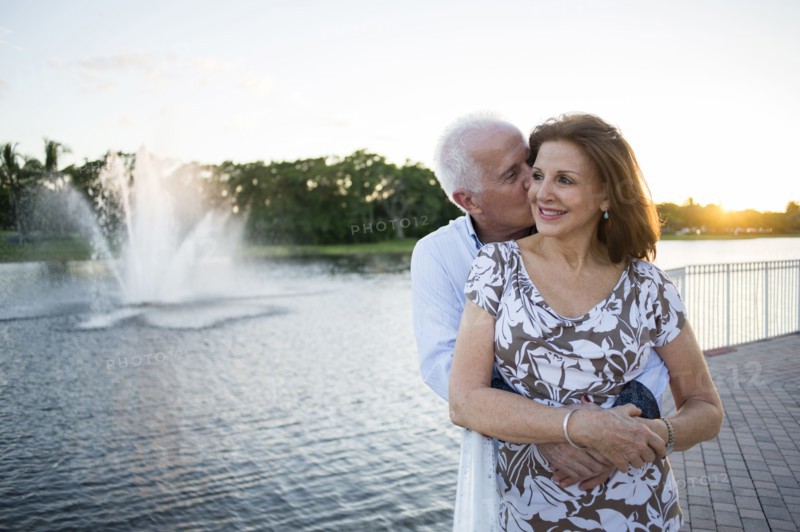 Older Caucasian couple hugging by fountain