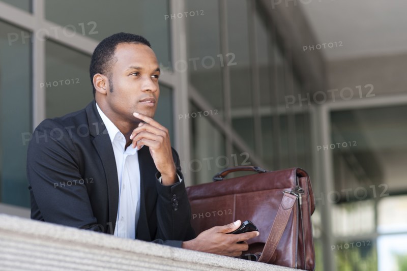 Black businessman thinking outside building