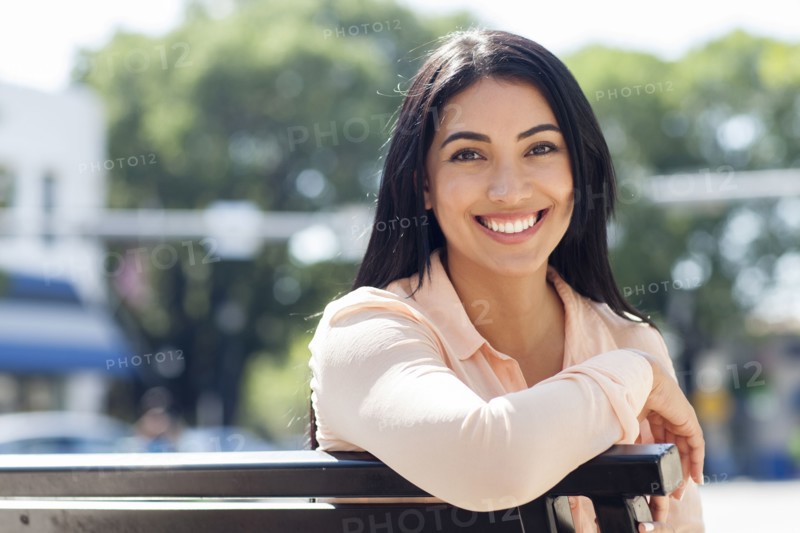Hispanic woman smiling on bench