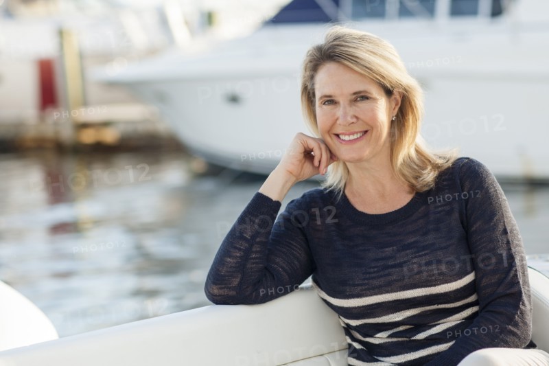 Caucasian woman sitting on boat in harbor