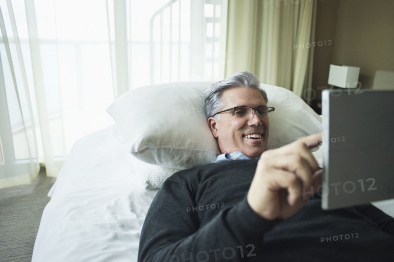 Caucasian man using digital tablet in bed