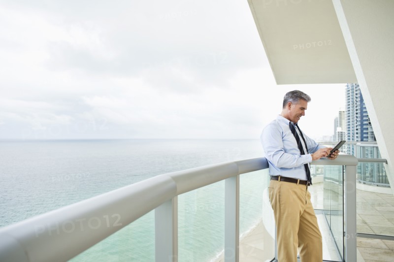 Caucasian businessman using digital tablet on balcony
