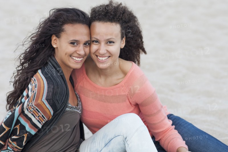 Smiling women hugging on beach