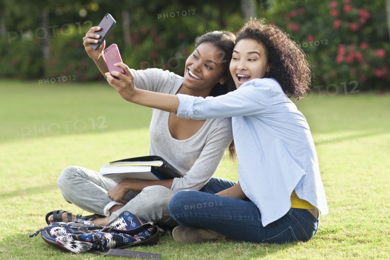 Black women taking selfies in park