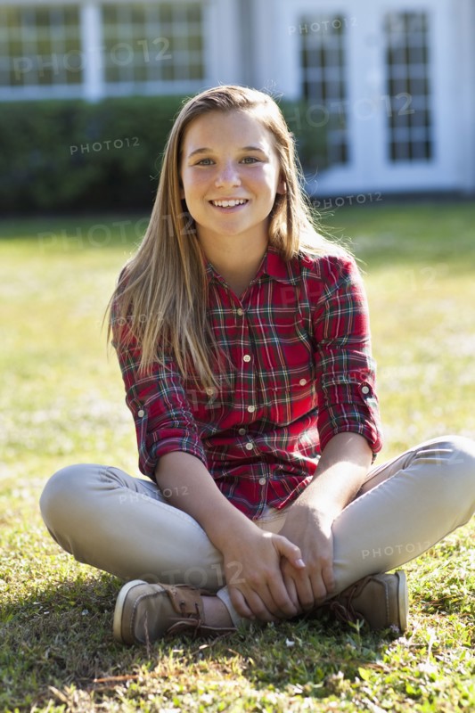 Caucasian girl sitting in backyard