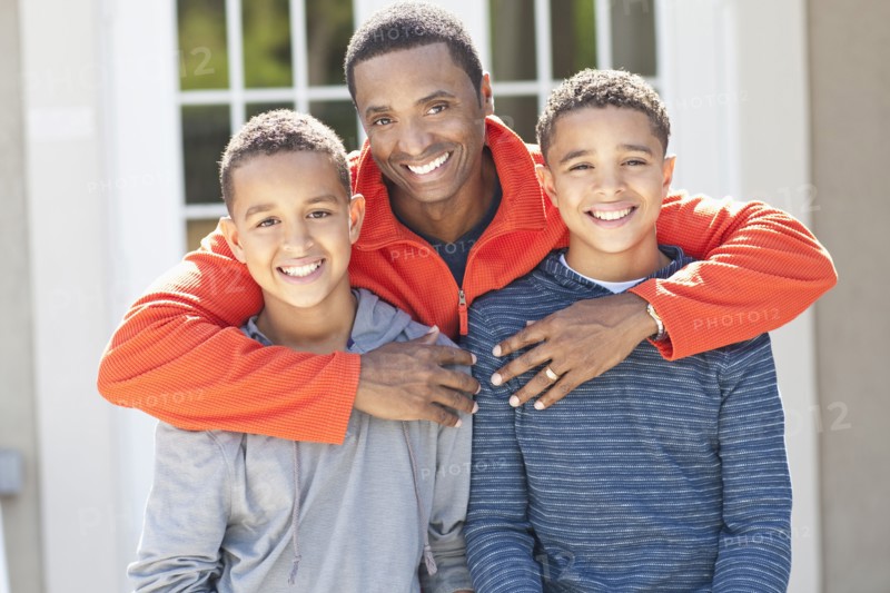 Father hugging sons outdoors